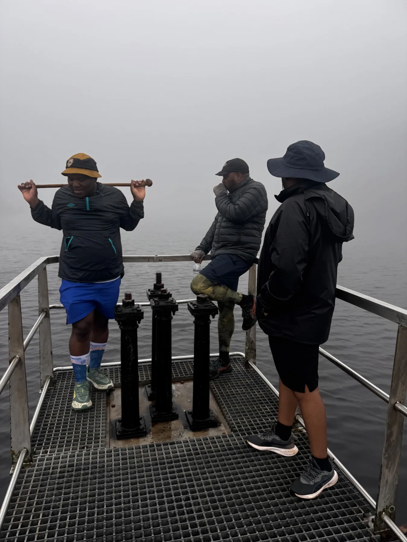 Three hikers on a misty platform